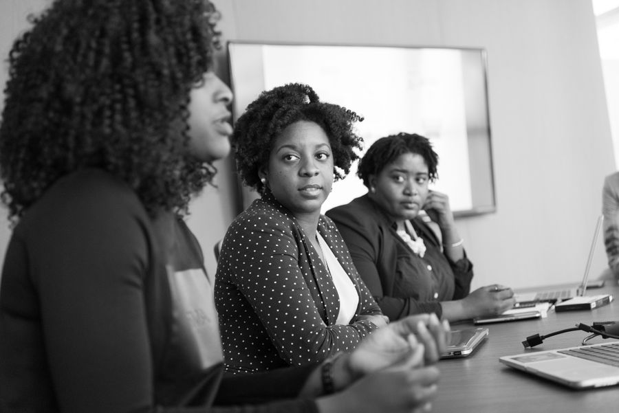 Three Black women collaborating in an office meeting